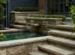 A closeup of a natural stone fountain feature surrounded by stairs